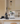 White La Marzocco coffee machine on a kitchen counter with books and a green mug in the background.