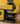 La Marzocco Yellow coffee grinder with a person adjusting it on a wooden surface.