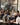 Group of people sitting on a couch in a modern coffee shop with glass walls.