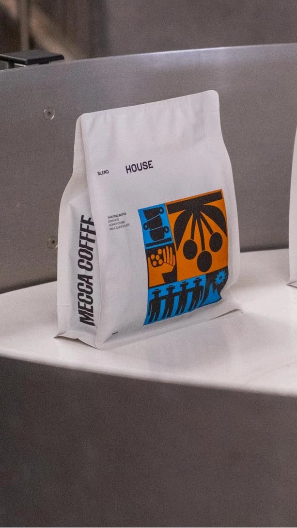 Three coffee bags with colorful labels on a metallic surface